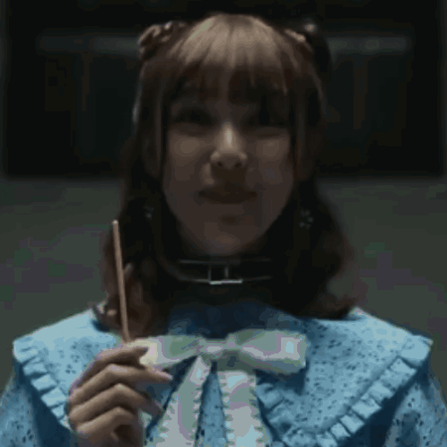 A Woman In A Blue Dress Holds A Stick In Her Hand GIF