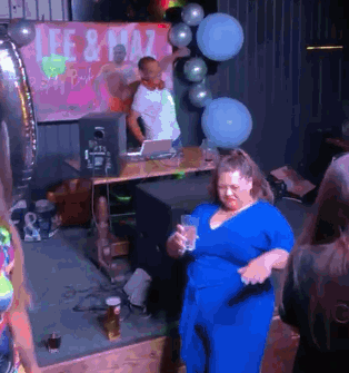 A Woman In A Blue Dress Is Dancing In Front Of A Sign That Says Lee & Plaza GIF