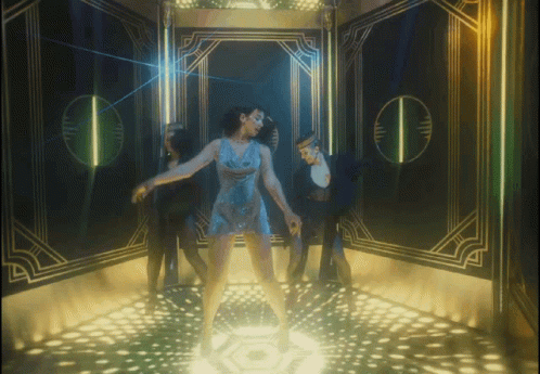 A Woman In A Blue Dress Is Dancing On A Stage GIF