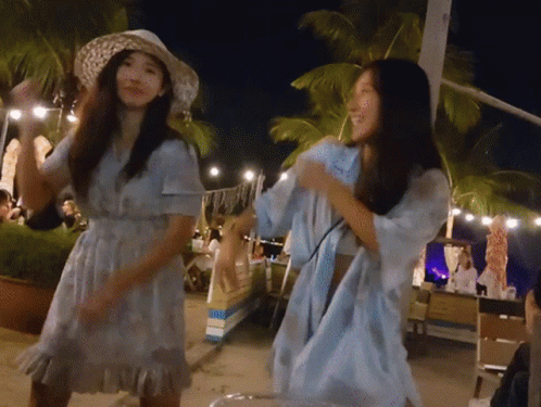 A Woman In A Blue Dress Is Dancing With Another Woman GIF