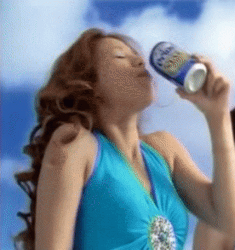A Woman In A Blue Dress Is Drinking From A Can Of Beer GIF