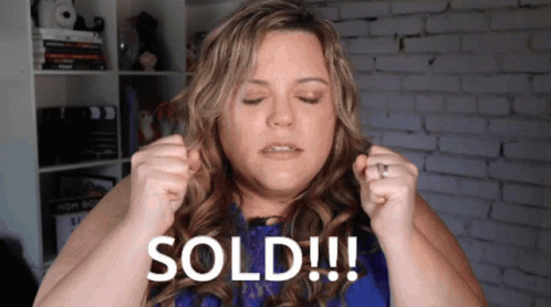 A Woman In A Blue Dress Is Holding Her Hair Up And Says Sold GIF
