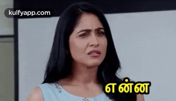 A Woman In A Blue Dress Is Making A Funny Face With A Foreign Language . GIF