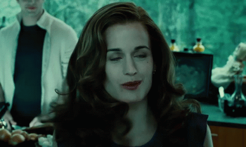 A Woman In A Blue Dress Is Making A Funny Face With Her Eyes Closed GIF