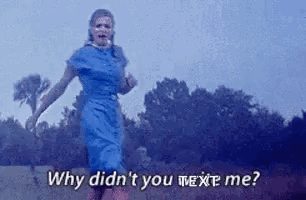 A Woman In A Blue Dress Is Running In A Field With The Words `` Why Didn 'T You Text Me '' . GIF