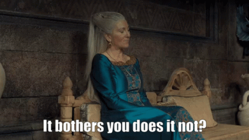A Woman In A Blue Dress Is Sitting On A Throne With The Words It Bothers You Does It Not GIF