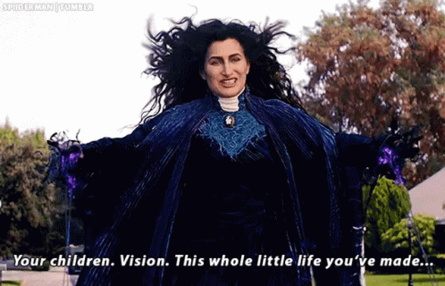 A Woman In A Blue Dress Is Standing In A Park With Her Arms Outstretched And Talking To Someone . GIF