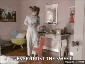 A Woman In A Blue Dress Is Standing In A Room Next To A Desk . GIF