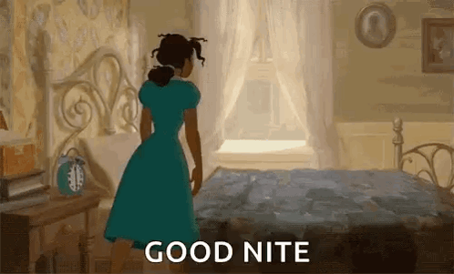 A Woman In A Blue Dress Is Standing In Front Of A Bed In A Bedroom And Saying `` Good Nite '' . GIF