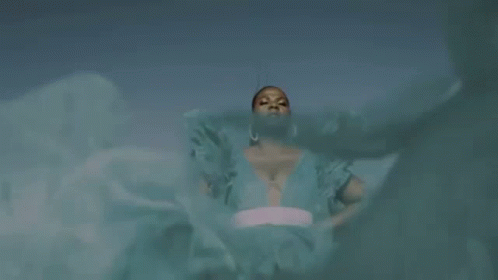 A Woman In A Blue Dress Is Standing In Front Of A Blue Sky With The Words `` Queen Of My Castle '' Above Her . GIF