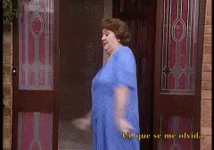 A Woman In A Blue Dress Is Standing In Front Of A Door That Says " U-Que Se Me Olvida " GIF