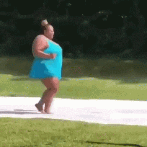 A Woman In A Blue Dress Is Walking Barefoot On A White Surface . GIF