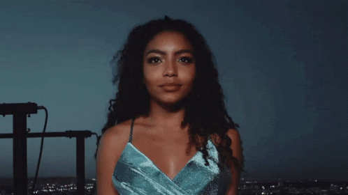 A Woman In A Blue Dress Looks At The Camera GIF