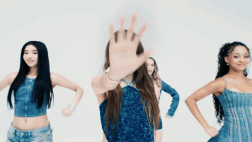 A Woman In A Blue Dress Stands In Front Of A Group Of Women GIF