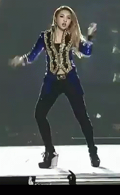 A Woman In A Blue Jacket And Black Pants Is Dancing On Stage GIF