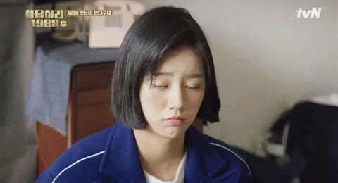 A Woman In A Blue Jacket Is Making A Funny Face . GIF