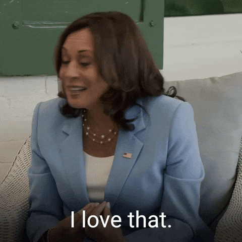 A Woman In A Blue Jacket Is Sitting On A Couch And Says I Love That GIF
