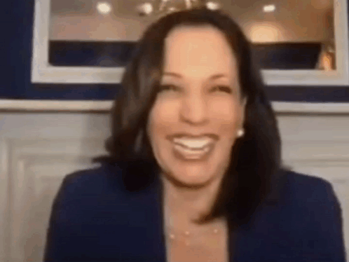 a woman in a blue jacket is smiling in front of a mirror .