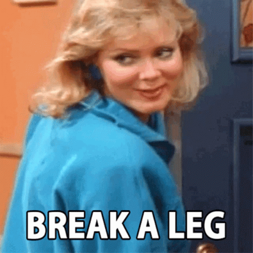 A Woman In A Blue Jacket Is Standing In Front Of A Door With The Words Break A Leg Written On It GIF