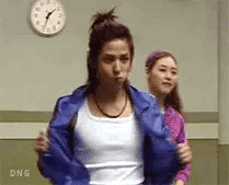 A Woman In A Blue Jacket Is Standing Next To Another Woman In A Pink Shirt . GIF
