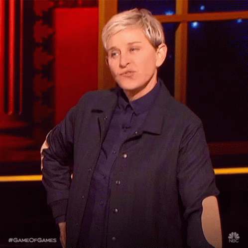 A Woman In A Blue Jacket Is Standing On A Stage With Her Hands In Her Pockets . GIF