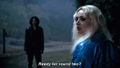 A Woman In A Blue Jacket Says " Ready For Round Two " In Front Of A Man In A Black Jacket GIF