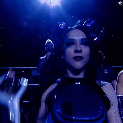 A Woman In A Blue Outfit Holds Up A Trophy GIF