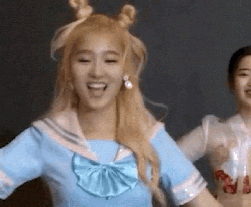 A Woman In A Blue Sailor Outfit Is Dancing With Another Woman . GIF