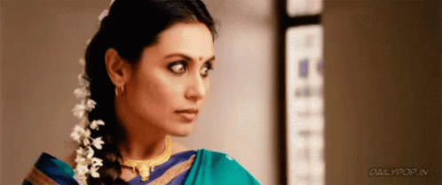 A Woman In A Blue Saree Is Looking At The Camera . GIF