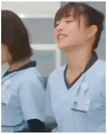 a woman in a blue scrub top is standing next to another woman .