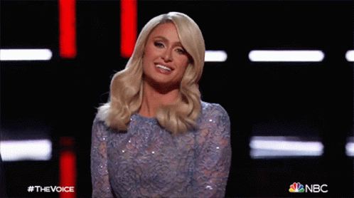 A Woman In A Blue Sequined Dress Is Waving At The Camera On Nbc 'S The Voice Show GIF