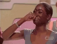 A Woman In A Blue Shirt Is Covering Her Nose With Her Hand GIF