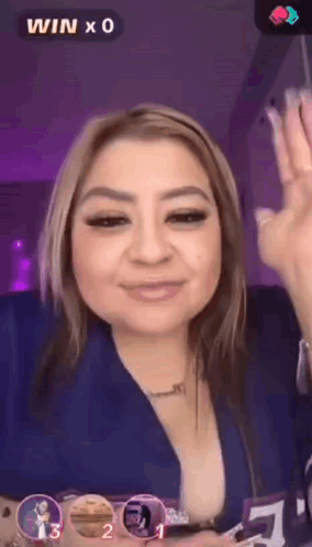 a woman in a blue shirt is giving a thumbs up sign