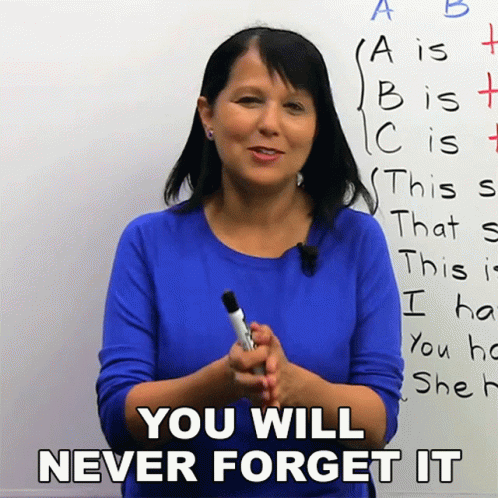 A Woman In A Blue Shirt Is Holding A Marker In Front Of A White Board That Says You Will Never Forget It GIF