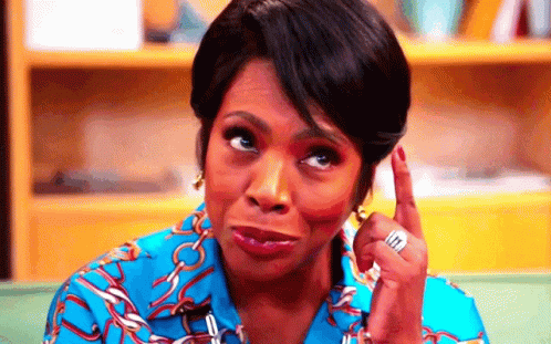 A Woman In A Blue Shirt Is Making A Funny Face While Pointing Up . GIF