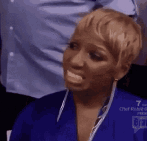 a woman in a blue shirt is making a funny face with her mouth open .