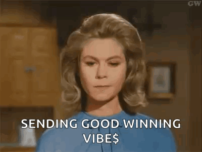 A Woman In A Blue Shirt Is Sending Good Winning Vibes To Someone . GIF