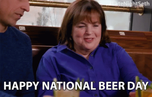 A Woman In A Blue Shirt Is Sitting Next To A Man In A Restaurant And Says Happy National Beer Day GIF