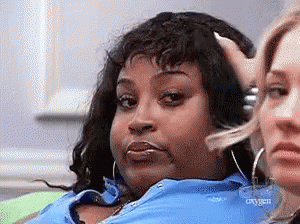 A Woman In A Blue Shirt Is Sitting Next To Another Woman Who Is Making A Funny Face . GIF