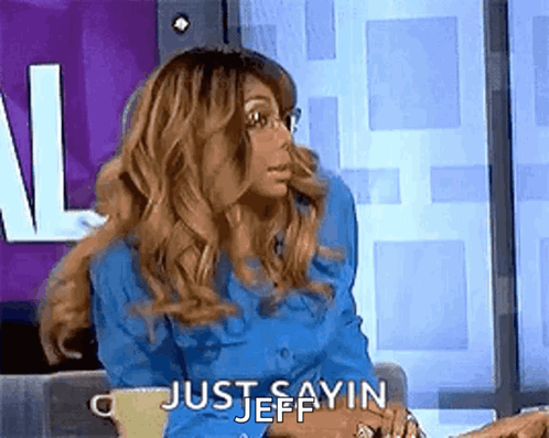 A Woman In A Blue Shirt Is Sitting On A Couch With A Cup Of Coffee And Saying `` Just Sayin Jeff '' . GIF