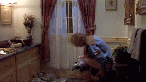 A Woman In A Blue Shirt Is Sitting On A Toilet GIF