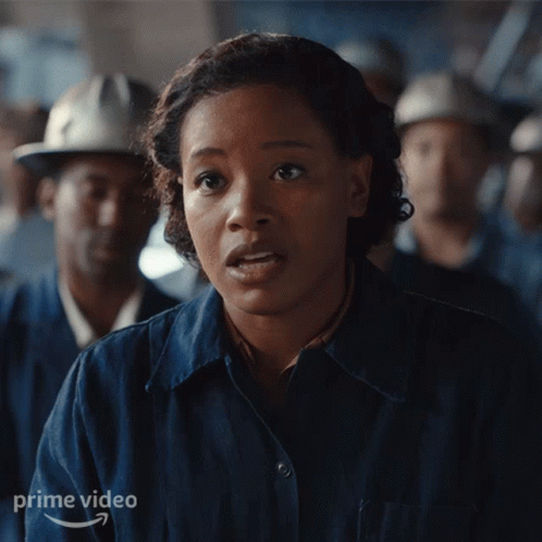 Woman In Blue Shirt In Front Of Men With Hard Hats GIF