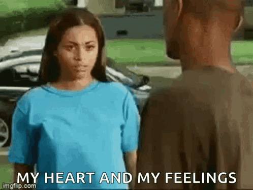 A Woman In A Blue Shirt Is Standing Next To A Man In A Brown Shirt And Saying `` My Heart And My Feelings '' . GIF