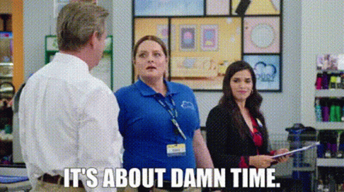 A Woman In A Blue Shirt Is Talking To A Man In A Store . GIF