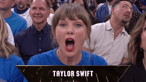 A Woman In A Blue Shirt With The Name Taylor Swift On The Bottom Right GIF