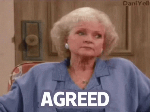 A Woman In A Blue Shirt With The Word Agreed On Her Chest GIF