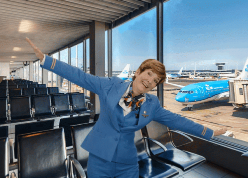 A Woman In A Blue Stewardess Uniform Stands In Front Of A Klm Airplane GIF