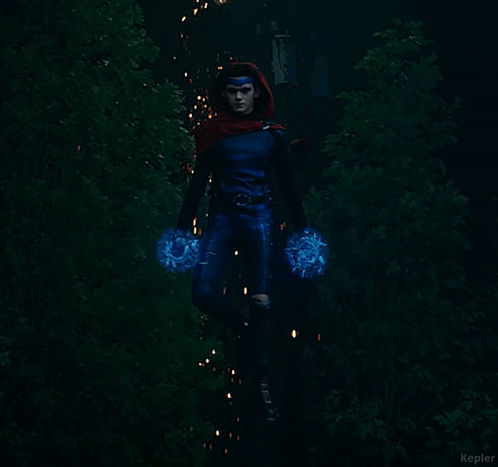 A Woman In A Blue Superhero Costume Is Holding A Blue Object In Her Hands GIF