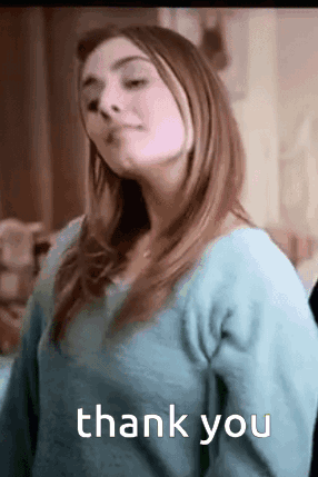 A Woman In A Blue Sweater Is Giving A Thank You . GIF