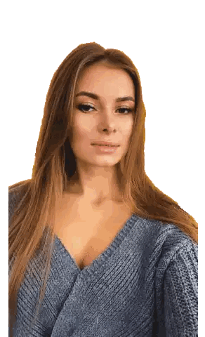 a woman in a blue sweater is taking a picture of herself